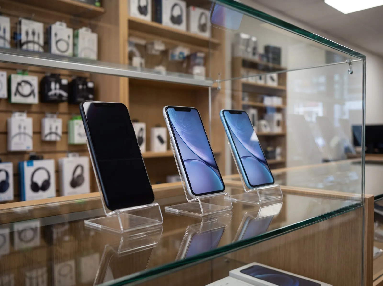 Tres celulares nuevos en exhibición dentro de una vitrina